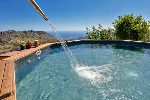 een zwembad met een fontein bij Best View Mountain Villa in Teménia