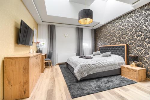 a bedroom with a bed and a tv on a wall at Toress Apartamenty Kaskada in Szczecin