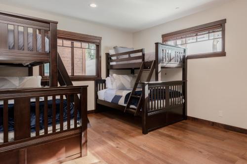 a room with three bunk beds and a staircase at Mountainside 5 in Mammoth Lakes