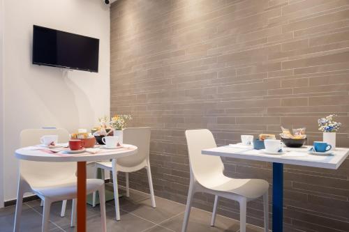 a dining room with two tables and chairs and a tv at Torri & Portici in Bologna