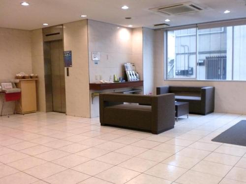een lobby met een wachtkamer met banken en een raam bij Smile Hotel Mito in Mito