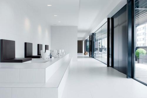a hallway of a building with white walls and windows at Carbon Hotel in Genk