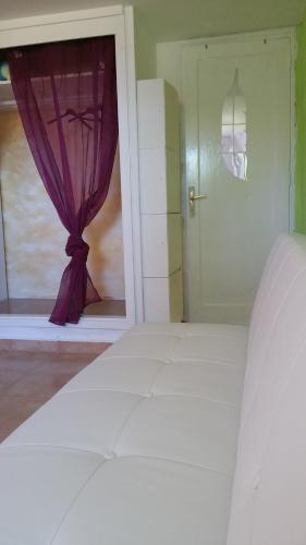 a bedroom with a window with a purple curtain at Flor de Loto -Finquita Lotusflower in Aguatona