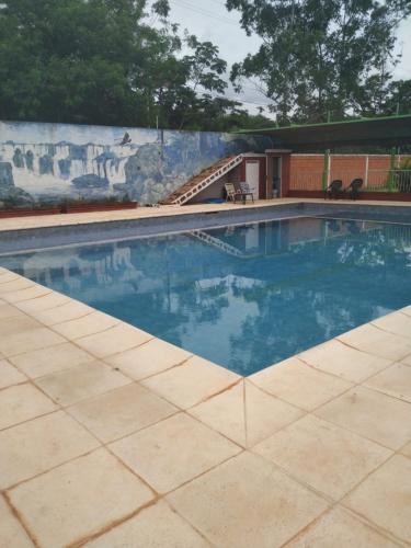 a swimming pool with blue water in front of a wall at Mi Buen Refugio in Puerto Iguazú