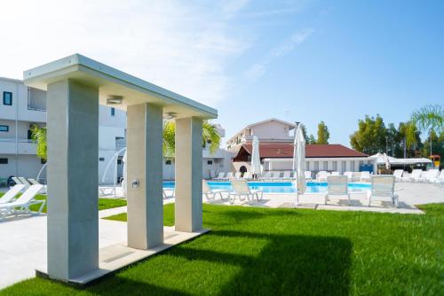 a pool with chairs and a pavilion in a yard at Sibari Residence in Marina di Sibari