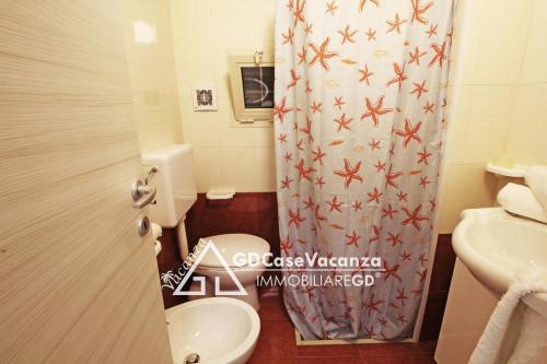 トッレ・デル・オルソにあるGD Case Vacanza -Moderno con ampia veranda-のバスルーム(トイレ、シャワーカーテン付)
