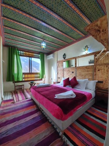 a bedroom with a large bed in a room with green ceilings at Riad Atlas Imlil in Imlil