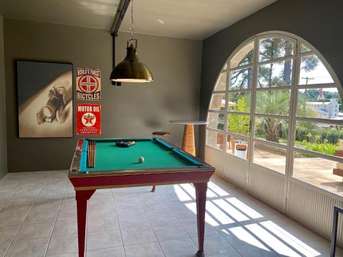 a room with a pool table and a window at Hotel Casacurta in Garibaldi