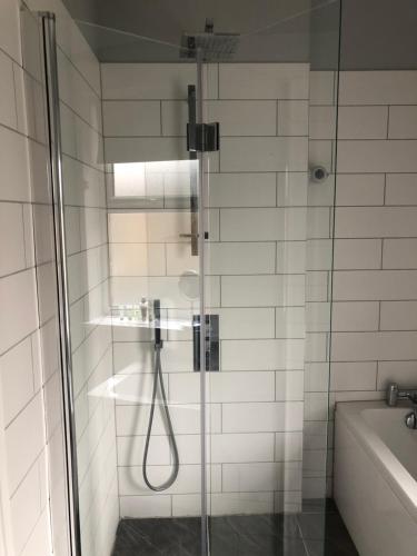 a shower with a glass door in a bathroom at Margate's Modern Luxury Apartment in Margate