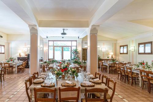 een eetkamer met tafels en stoelen met bloemen bij Agriturismo La Dolza in Follina