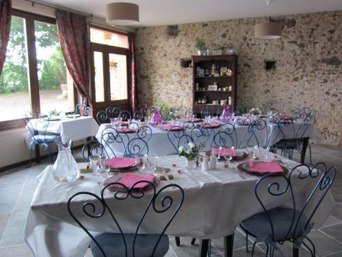 - une salle à manger avec des tables, des chaises et des serviettes roses dans l'établissement La Ferme du Bascou, à Madière