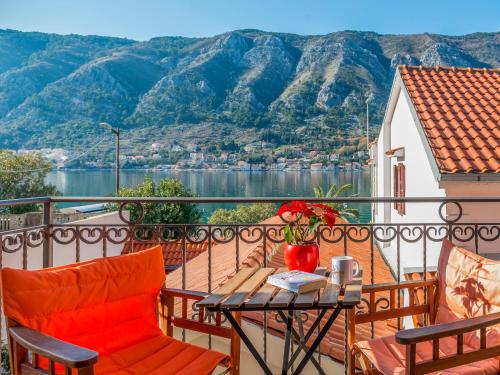 a balcony with a table and chairs and mountains at Apartments Windrose in Kotor