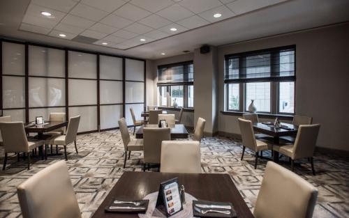 - une salle à manger avec des tables, des chaises et des fenêtres dans l'établissement Magnolia Hotel Downtown Dallas, à Dallas