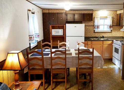 a kitchen with a table and a white refrigerator at The Aspen Cabin in Wilmington