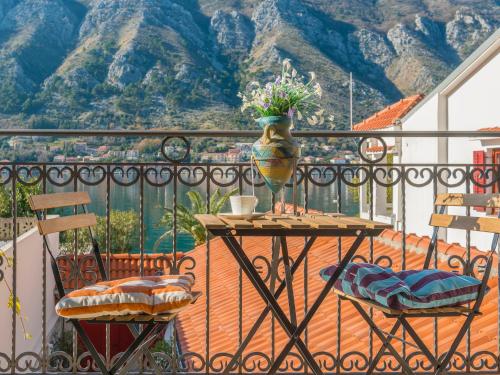 einen Balkon mit einem Tisch und einer Vase darauf in der Unterkunft Apartments Windrose in Kotor