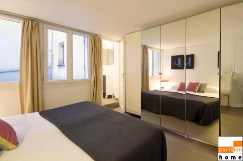 a bedroom with a bed and a large window at 202419 - Elegant apartment for 6 people in the Montorgueil area in Paris