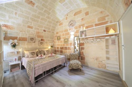 a bedroom with a bed in a stone walled room at 30 METRI QUADRATI in Monopoli