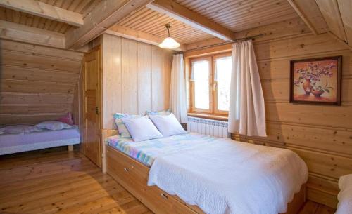 a bedroom with a bed in a wooden room at Pokoje u Uli in Kościelisko