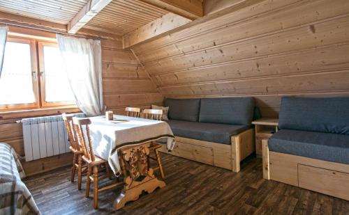 a room with a table and a couch in a cabin at Pokoje u Uli in Kościelisko