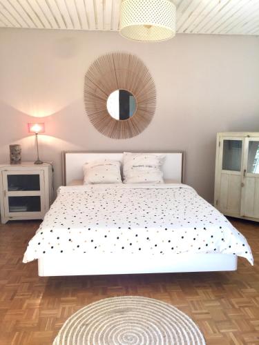 a bedroom with a white bed with a mirror on the wall at villa MILA in Ravine Sèche