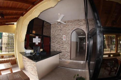 Caribbean Hotel Santo Domingo في سانتو دومينغو: لوبي مطعم مع كونتر مع مرآة