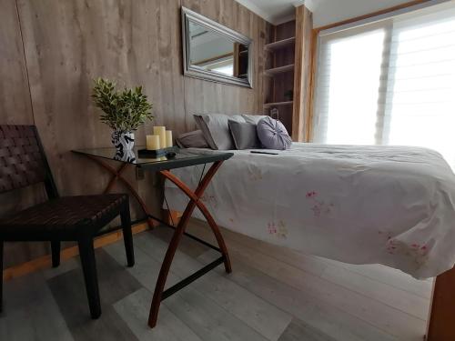 a bedroom with a bed and a table and a chair at Espacio Innata in Punta Arenas