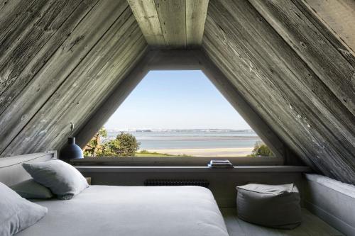 een bed in een kamer met een groot raam bij La Chaumière in Honfleur