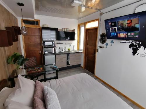 a room with a bed and a flat screen tv at Espacio Innata in Punta Arenas