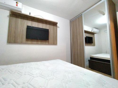 a bedroom with a bed and a flat screen tv at 2 Quartos com Piscina Aquecida Melhor Bairro Brasília in Brasilia