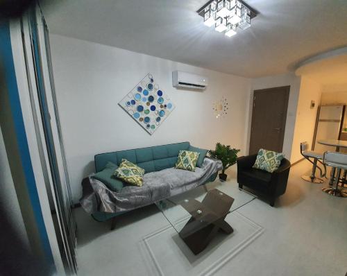 a living room with a blue couch and a table at Luxury 2 bed Apartment next to the Beach in Paralimni
