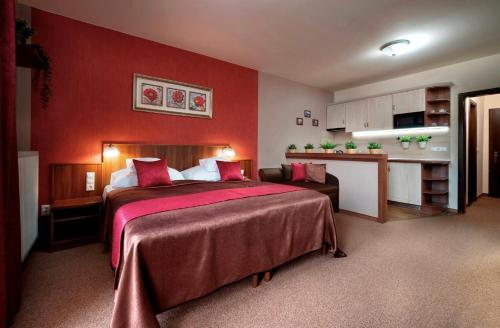 a bedroom with a bed and a red wall at Ambrózia Étterem és Panzió in Kazincbarcika