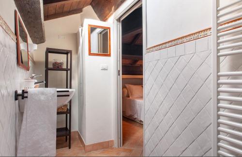 a bathroom with a sink and a door to a bedroom at Antica Residenza Montereano in Gubbio
