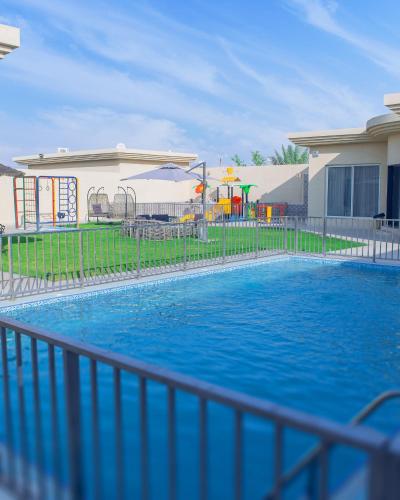 - une piscine dans une cour avec une aire de jeux dans l'établissement شاليهات فيفيان بارك Vivian Park Chalets, à Al Kharj