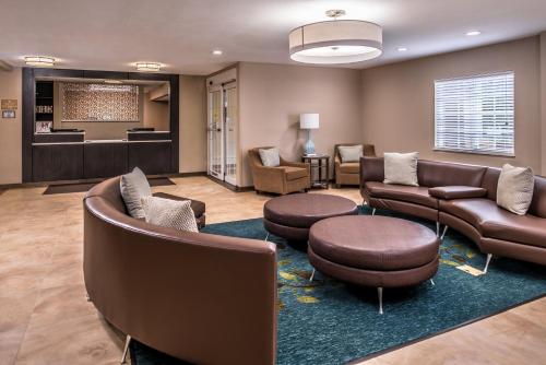 a waiting room with couches and chairs and a salon at Candlewood Suites Kansas City by IHG in Kansas City