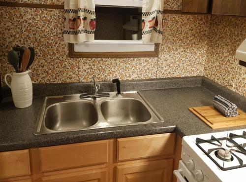 a kitchen with a sink and a stove at The Aspen Cabin in Wilmington