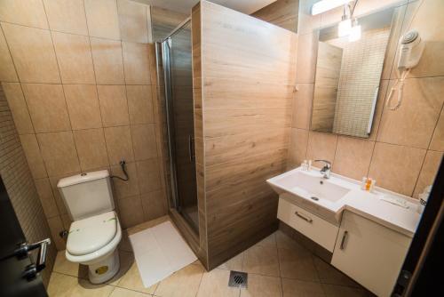 a bathroom with a toilet and a shower and a sink at Hotel Atlas Ugljevik in Ugljevik