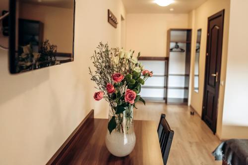 a vase filled with flowers sitting on a table at Villa Kmeller in Lviv