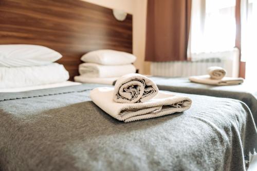 a couple of beds with towels on the bed at Villa Kmeller in Lviv
