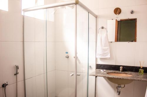 een badkamer met een douche en een wastafel bij Riviera Palace Hotel in Sete Lagoas