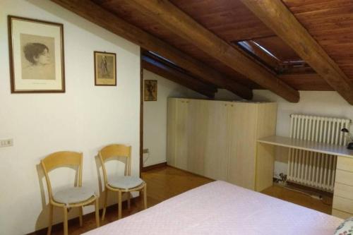 a bedroom with two chairs and a bed in a room at Casa DA.MA. CORNARO centro storico in Asolo
