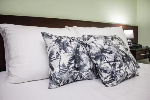 Riviera Palace Hotel في سيت لاغواس: وسادة سوداء وبيضاء فوق السرير