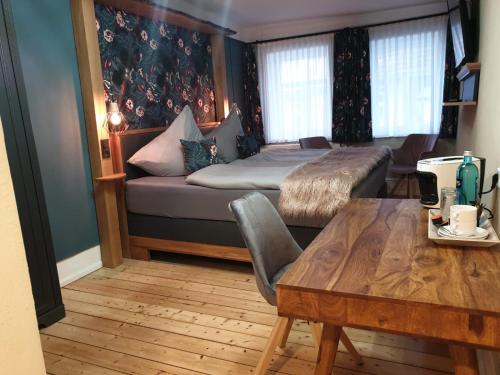 バート・ゾーデン・アレンドルフにあるPelikans Kroneのベッド1台、テーブル、ベッド1台、ソファが備わる客室です。