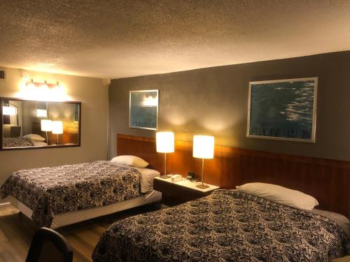 Habitación de hotel con 2 camas y espejo en Western Inn, en Houston
