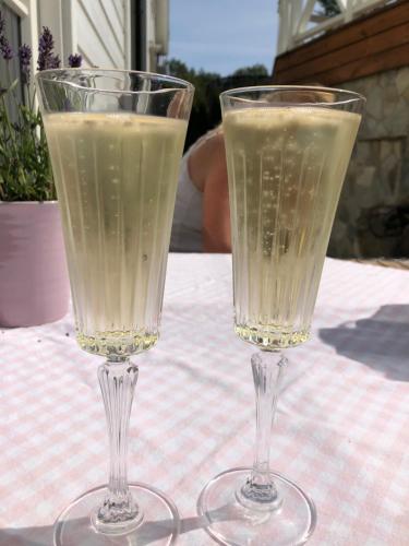 dos copas de champán sentadas en una mesa en Peaceful Cottage en Gotemburgo