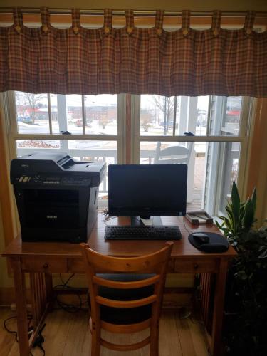 a desk with a laptop and a monitor at Country Inn at the Mall in Bangor