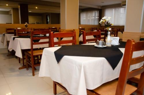 a restaurant with tables and chairs with white table cloth at Ilhabela Park Hotel in Brasilia