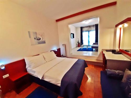 a bedroom with a large bed and a desk and a room at Rooms Vodisek - Depandansa Hotela Capris Capodistria Boutique in Koper