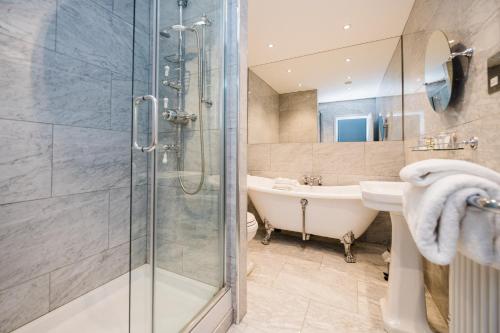 a bathroom with a shower and a tub and a sink at The Wrea Head Hall Country House Hotel & Restaurant in Scarborough