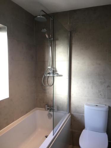 a bathroom with a tub, toilet and shower at Zen House Bath in Bath