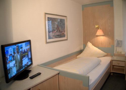 a bedroom with a bed with a television on a desk at Best Breakfast - Hotel Justina in Bad Wörishofen